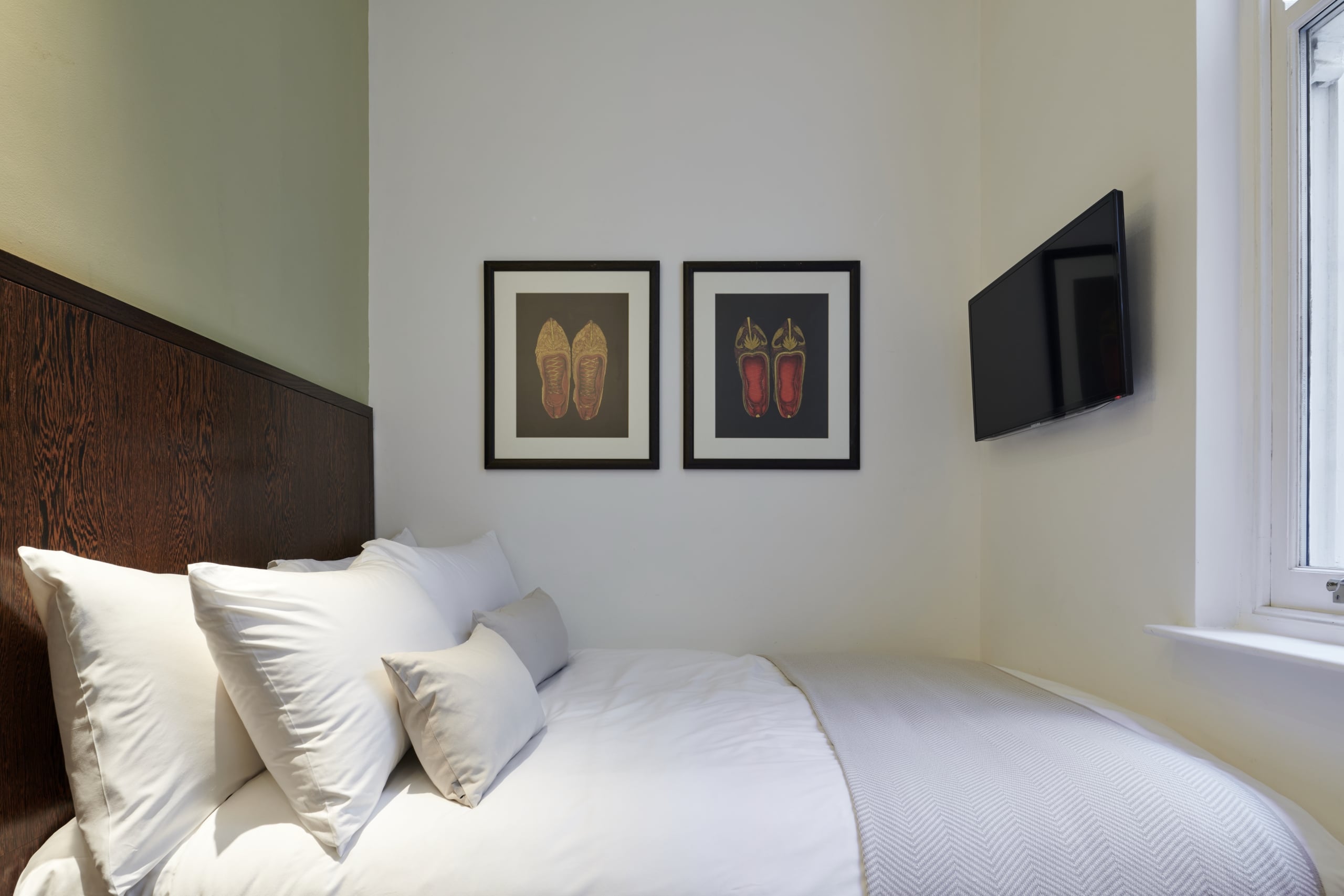 Standard double accommodation with a mounted TV and wall art